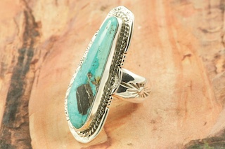 Genuine Sunnyside Turquoise set in Sterling Silver Ring. The matrix on this rare stone is outstanding. The Sunnyside mine is located in northern Nevada near the town of Tuscarora in the Tuscarora mountain range. The mine is no longer in operation as it has become part of a gold mining operation and a privately owned ranch. The Sunnyside mine was mined mostly in the 70's. You won't find much of this great turquoise around anymore except for old stashes. Created by Navajo Artist John Nelson. Signed by the artist.